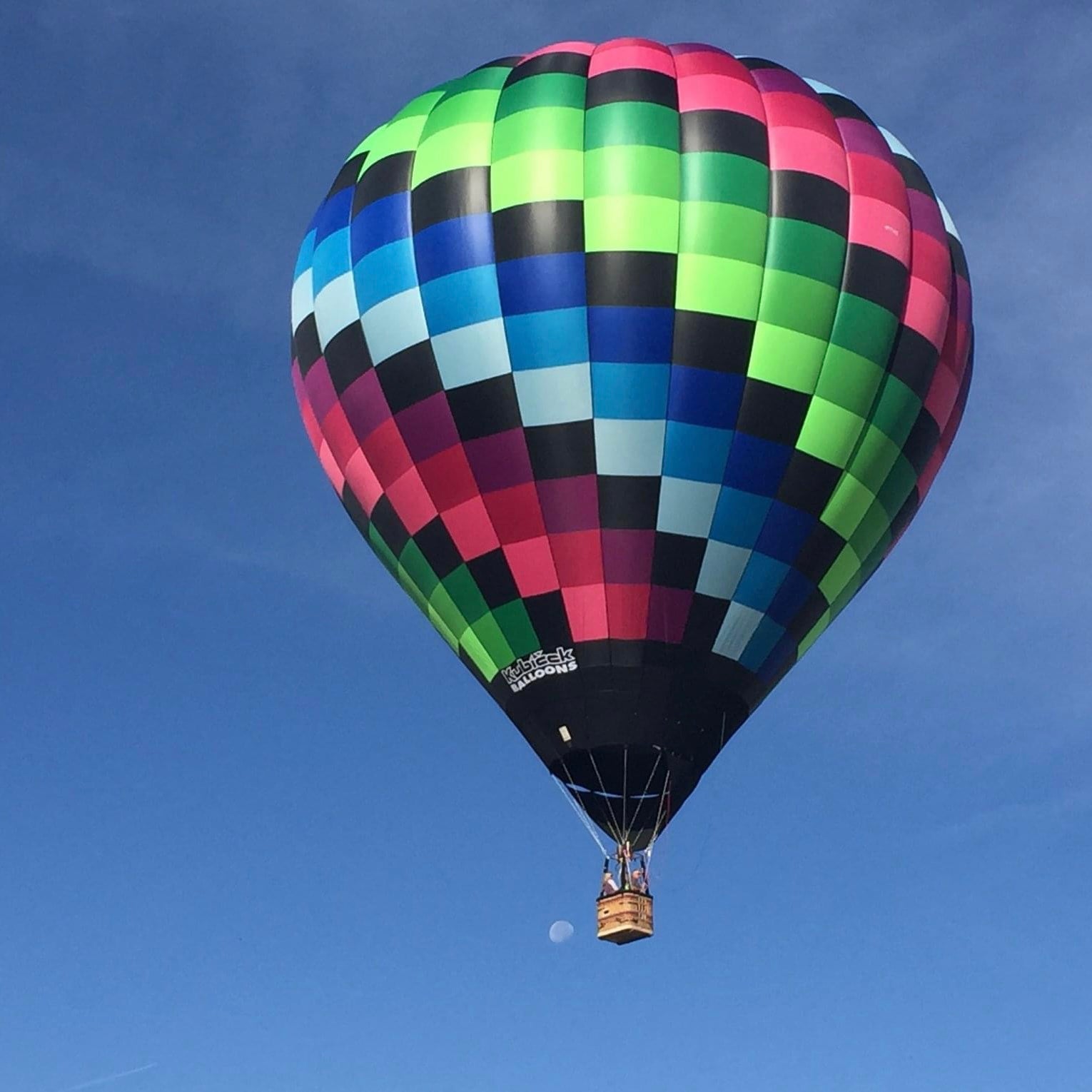 A picture of Pixie Dust (the hot air balloon) flying in the sky. Blue sky background 