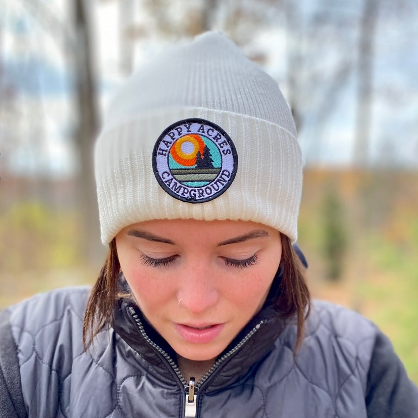 woman wearing patch hat in the woods