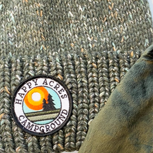 up close Beanie green spec hat with happy acres patch showing lining