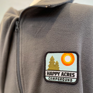 Fleece zip up jacket with Happy Acres patch on left chest close up