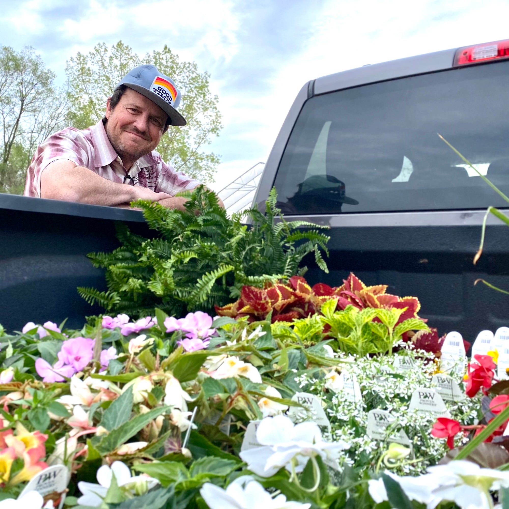 Kelley from Good Times Horticulture leaning over a truck bed full of flowers
