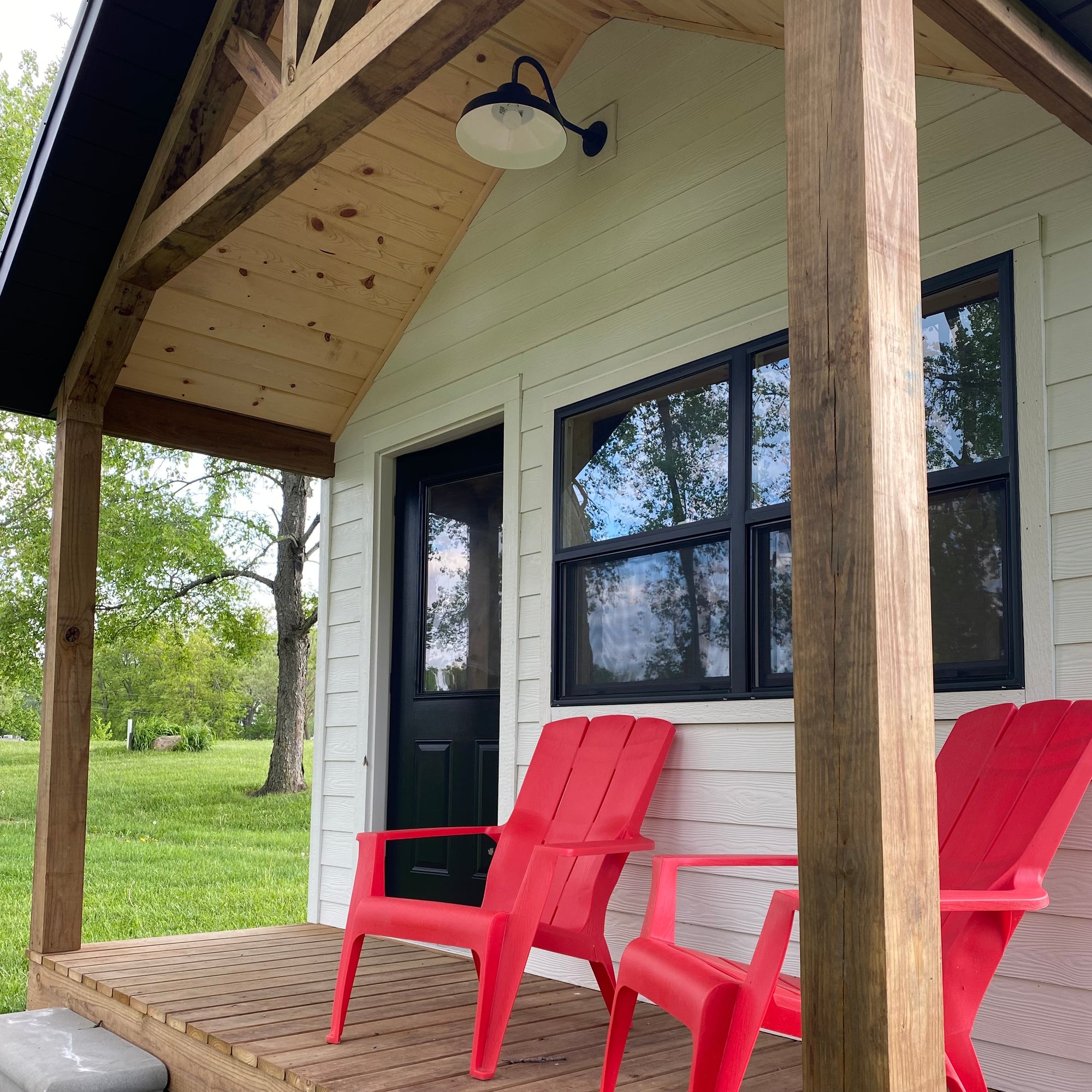close up view of cabin front porch with red adirondack chairs