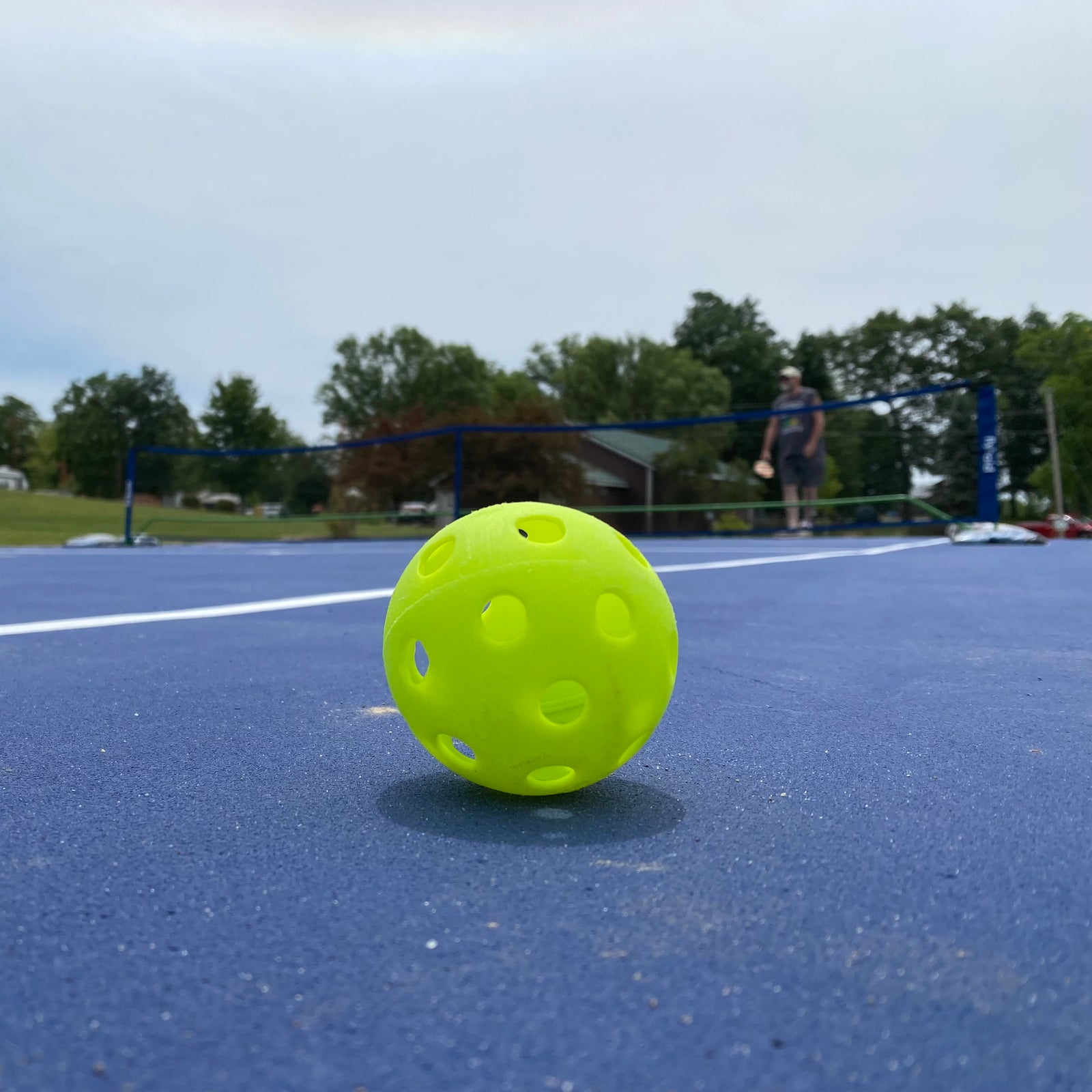 pickleball on a pickleball court with net in the background