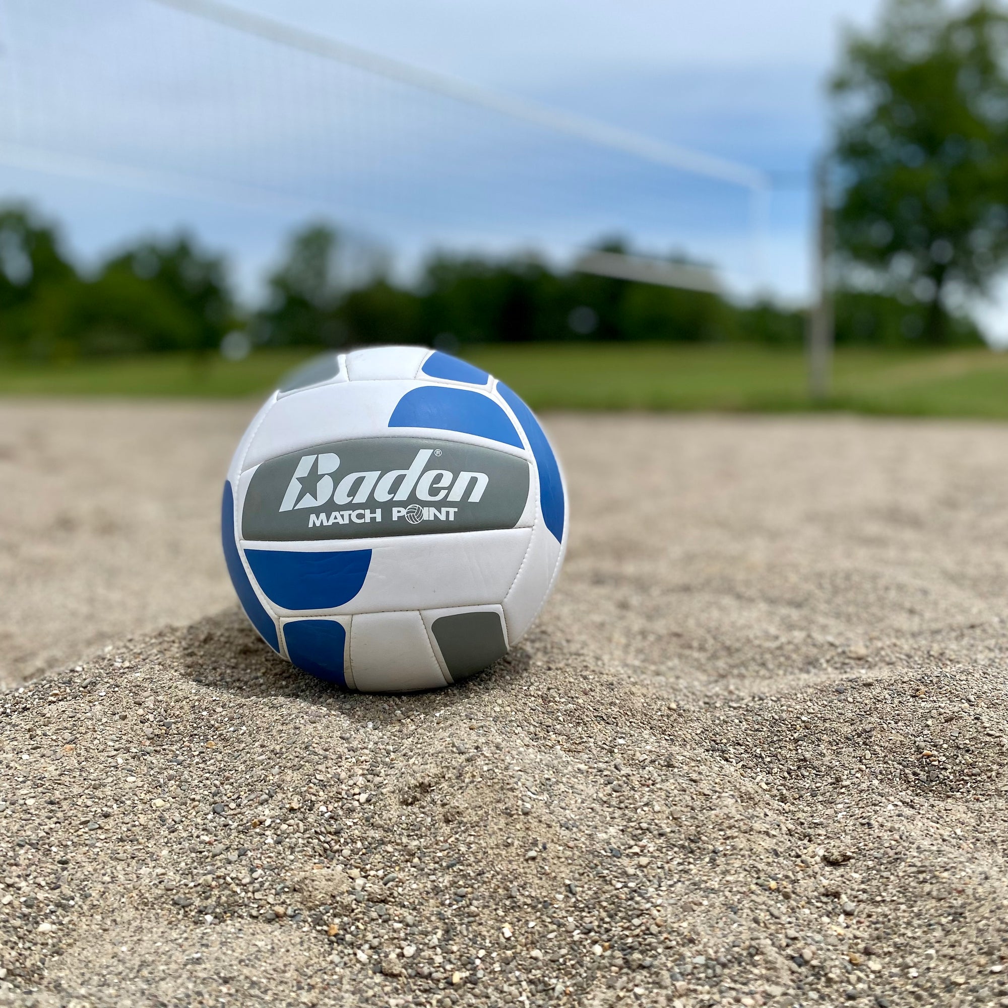 volley ball on a sand court with net in background