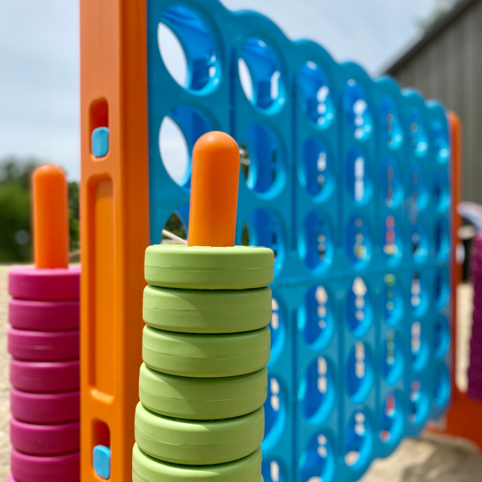 up close view of oversized connect 4 game - blue, orange, green, pink