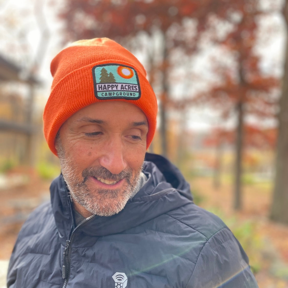 man wearing orange patch hat in the woods